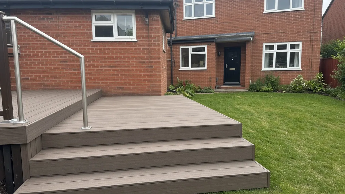 Example image: full-width composite steps with a brushed aluminium handrail leading from a deck to the lawn